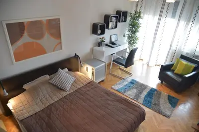 a bedroom with a bed and a chair and a desk at Apartment Danica in Belgrade