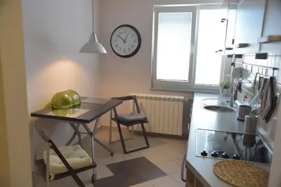 a kitchen with a table and a clock on the wall at Apartment Danica in Belgrade