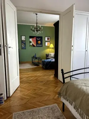 a living room with green walls and a chandelier at Ollio Washington Apart in Belgrade