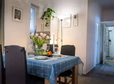 a table with a blue table cloth and flowers on it at Ollio Washington Apart in Belgrade
