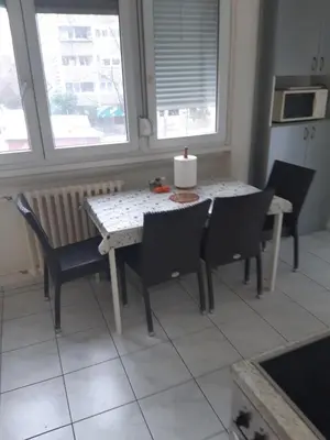 a table and chairs in a kitchen with a window at Stan in Belgrade