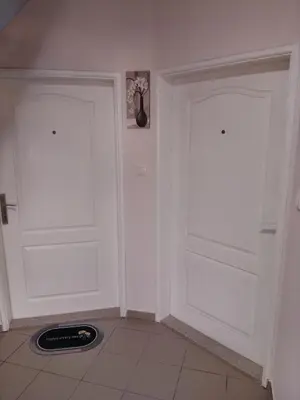 two white doors in a room with a tile floor at Apartman Lola in Lazarevac