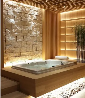 a bath tub in a room with a stone wall at Capo Zen