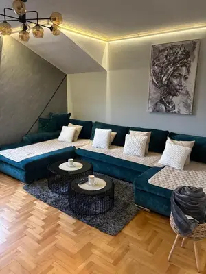 a living room with a blue couch and two tables at Apartman 23 in Belgrade