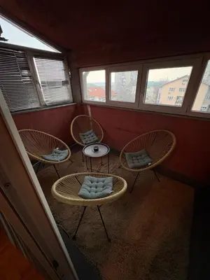 a room with three chairs and a table and windows at Apartman 23 in Belgrade