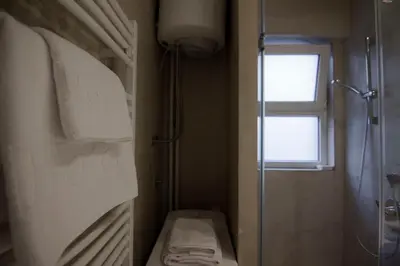 a bathroom with a shower and a toilet and a window at Studio Apartment Picasso in Belgrade