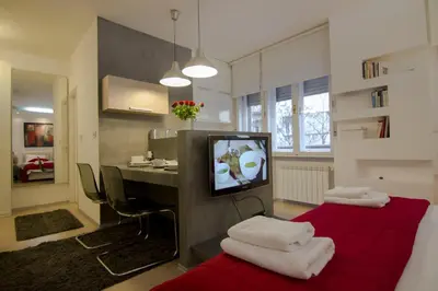 a living room with a red couch and a television at Studio Apartment Picasso in Belgrade