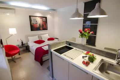 a bedroom with a bed and a kitchen with a sink at Studio Apartment Picasso in Belgrade