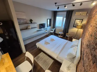 a room with a bed and a table and chairs at Apartment Madera in Belgrade