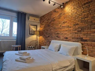 a bedroom with a brick wall and a bed with towels at Apartment Madera in Belgrade