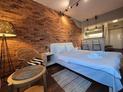 a bedroom with a bed and a brick wall at Apartment Madera in Belgrade