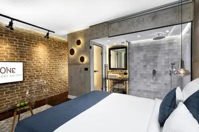 a bedroom with a bed and a brick wall at One Luxury Suites in Belgrade