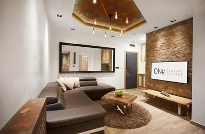 a living room with a couch and a mirror at One Luxury Suites in Belgrade
