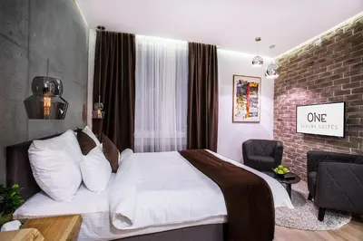 a bedroom with a bed and a brick wall at One Luxury Suites in Belgrade