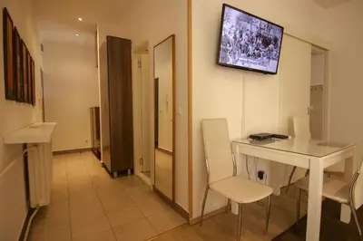 a room with a table and a television on the wall at Apartment Drama Center in Belgrade