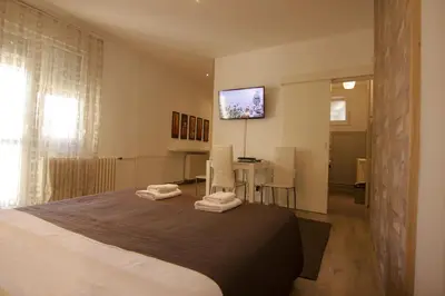 a bedroom with a bed and a table and a television at Apartment Drama Center in Belgrade