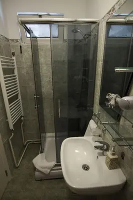 a bathroom with a sink and a glass shower at Apartment Drama Center in Belgrade