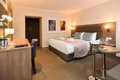 a hotel room with a bed and a desk at Hotel Opera Garni in Belgrade