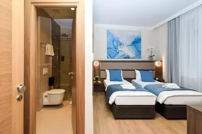 a bedroom with two beds and a bathroom at Hotel Opera Garni in Belgrade