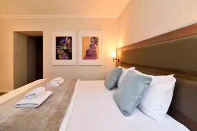 a bedroom with a bed with two towels on it at Hotel Opera Garni in Belgrade