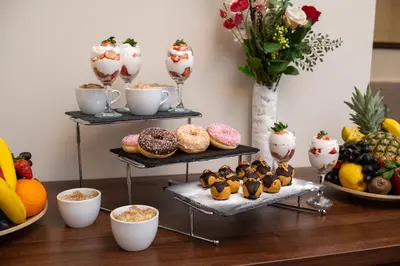 a table with two shelves of donuts and other desserts at Hotel Opera Garni in Belgrade
