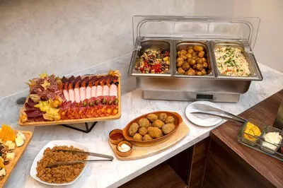 a buffet with many different types of food on a counter at Hotel Opera Garni in Belgrade