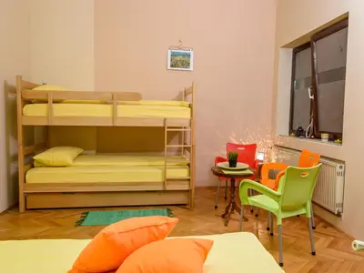a room with bunk beds and a table and chairs at Hostel White Town in Belgrade