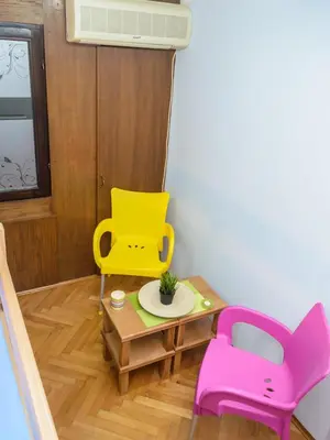 a toy room with a yellow and pink chair and a table at Hostel White Town in Belgrade