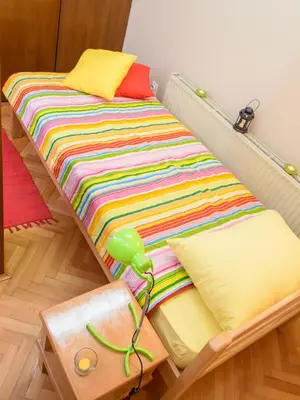a bed with colorful blankets and pillows in a room at Hostel White Town in Belgrade