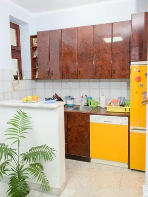 a kitchen with wooden cabinets and a yellow sink at Hostel White Town in Belgrade
