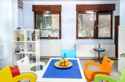 a room with a table with a bowl of fruit on it at Hostel White Town in Belgrade