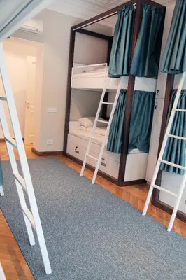 a room with two bunk beds and a mirror at Hostel Karavan Inn in Belgrade