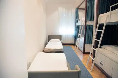 a small room with a bed and bunk beds at Hostel Karavan Inn in Belgrade