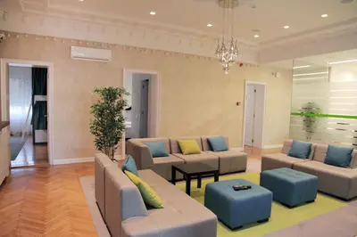 a living room with couches and a chandelier at Hostel Karavan Inn in Belgrade