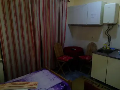 a small room with a bed and two chairs at Guest house Mirijevski Konak in Belgrade