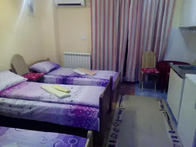 a bedroom with two beds and a table and chairs at Guest house Mirijevski Konak in Belgrade