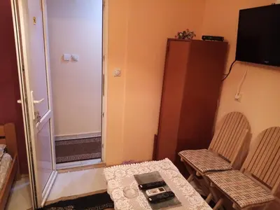 a small room with a shower and a table and chairs at Guest house Mirijevski Konak in Belgrade
