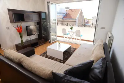 a living room with a couch and a large window at Apartments Belvedere in Belgrade
