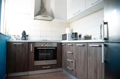a kitchen with wooden cabinets and a stainless steel refrigerator at Apartments Belvedere in Belgrade
