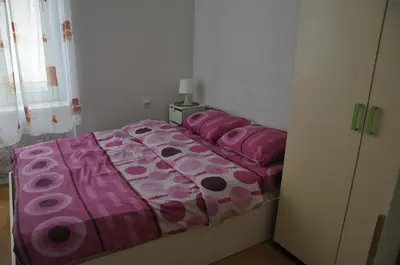 a bedroom with a bed with pink sheets and pillows at Apartment Angie in Belgrade