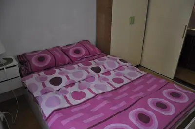 a pink bed with pink sheets andpillows at Apartment Angie in Belgrade