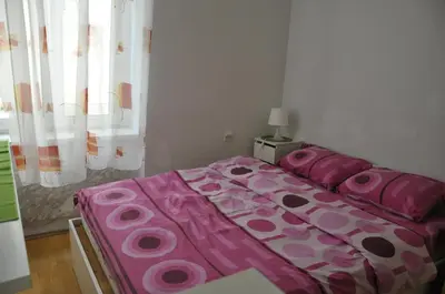 a bedroom with a bed with a pink comforter at Apartment Angie in Belgrade
