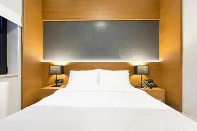 a bedroom with a large white bed and two lamps at Hotel Orasac Garni in Belgrade