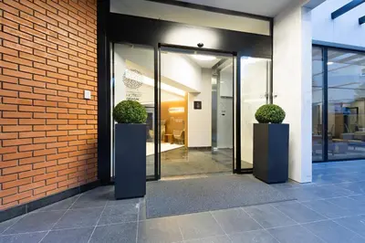 an entrance to a building with two potted plants at Hotel Orasac Garni in Belgrade