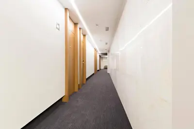 a corridor of an office building with white walls and a long hallway at Hotel Orasac Garni in Belgrade