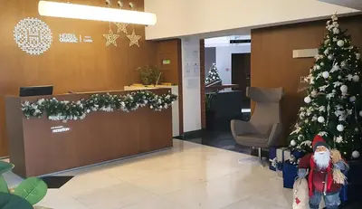 a christmas tree in a lobby with a santa clause at Hotel Orasac Garni in Belgrade