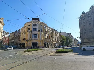 a large yellow building on a city street at Apartment Alloga in Belgrade