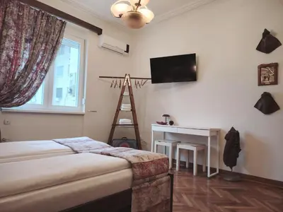 a bedroom with a bed and a desk and a television at Apartment Alloga in Belgrade