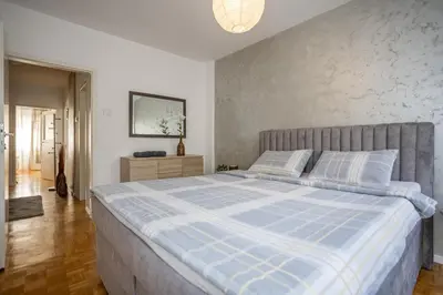 a bedroom with a bed with a blue and white comforter at Apartment Sara in Belgrade