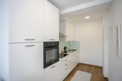 a white kitchen with white cabinets and a stove at Apartment Sara in Belgrade